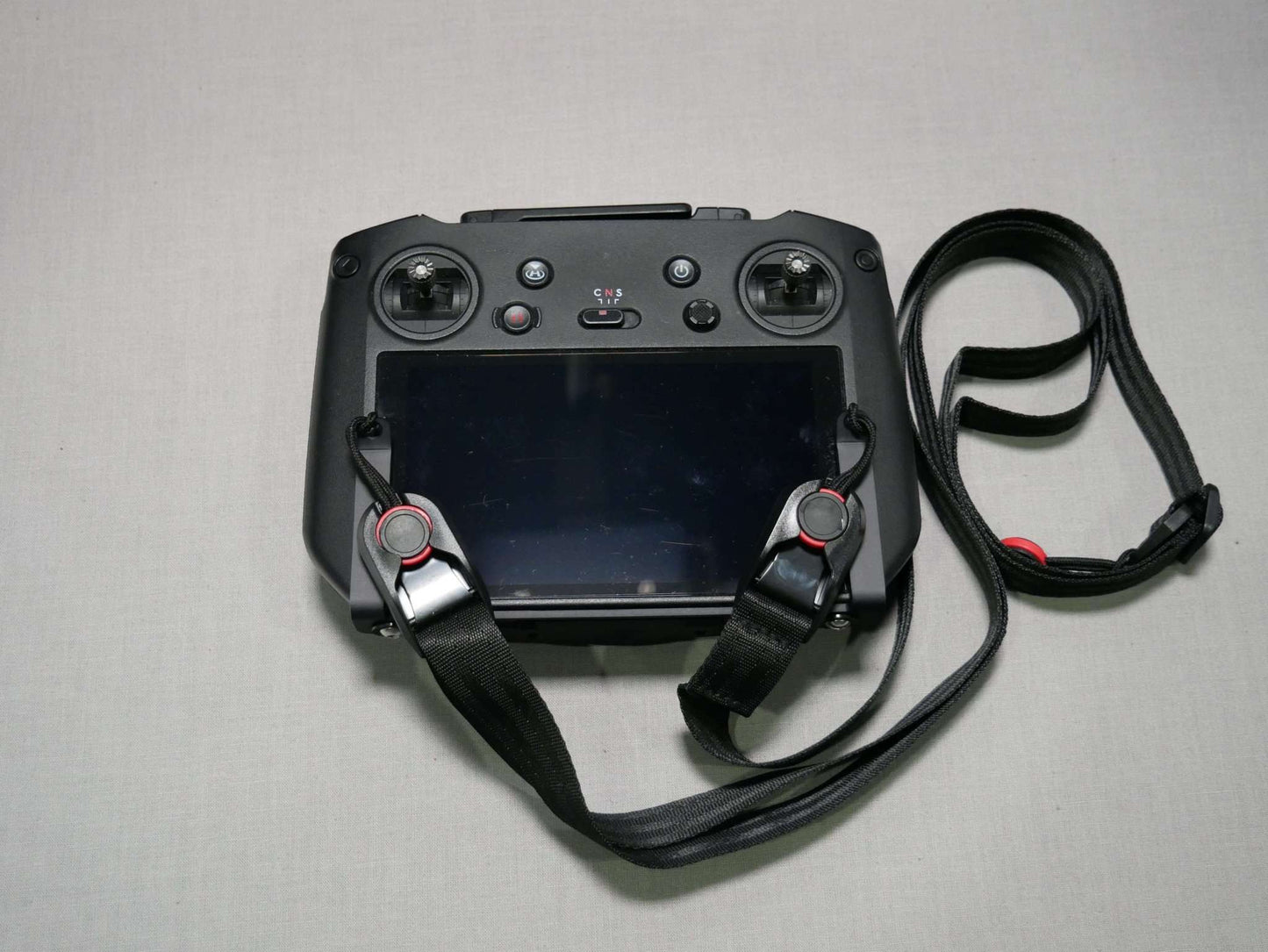 Halter mit Tragegurt in schwarz am DJI RC Pro Controller. Vorderansicht