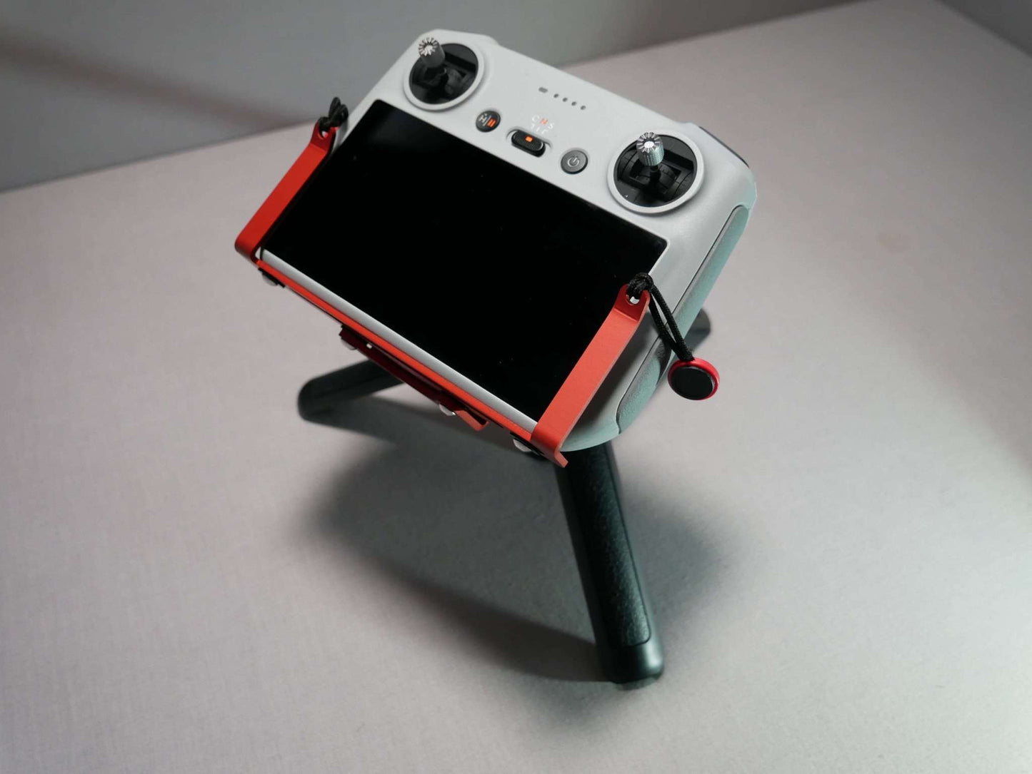 Montierter DFS-G- Stativhalter in rot am DJI RC Controller mit Halter für Halsgurt auf Stativ