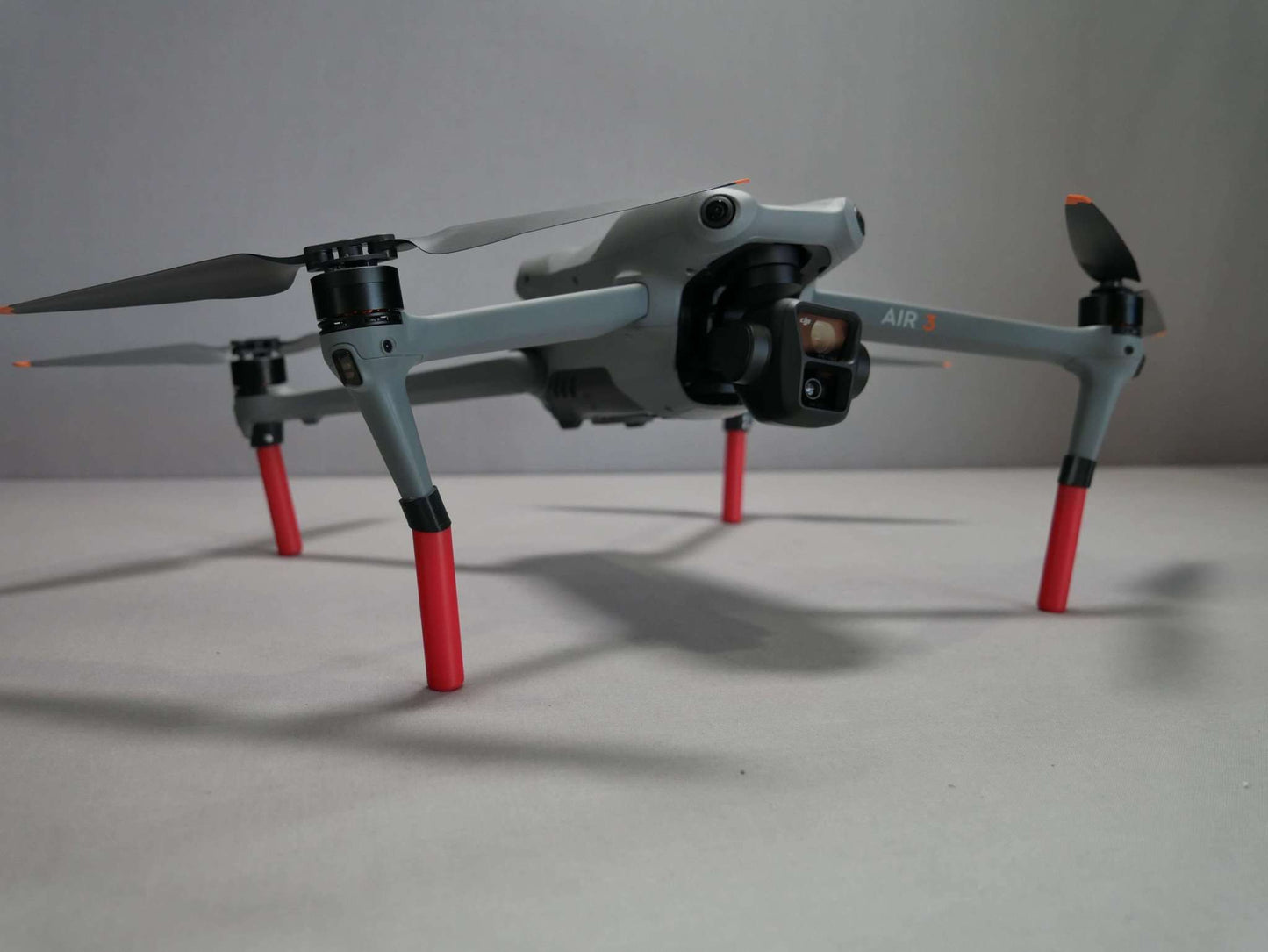 Landegestell System in rot angebracht an die DJI Air 3. Vorderansicht