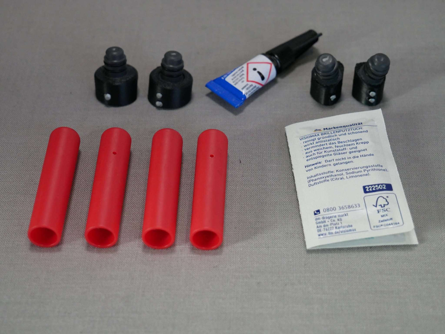 Lieferumfang Landegestell System rot: 4x Adapter, 4x Landefüße, 1x Reinigungstuch, 1 Tube Kleber