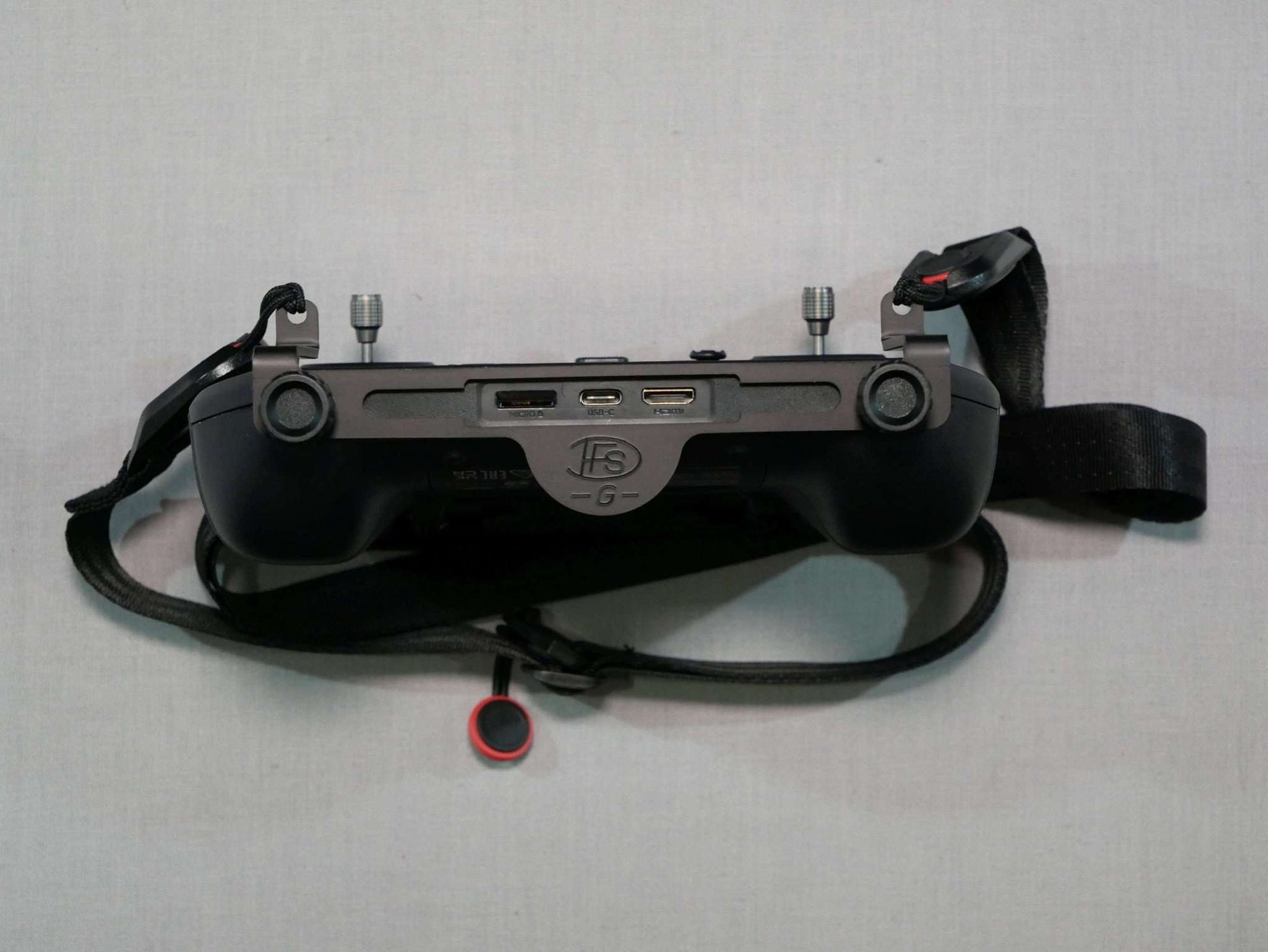 Halter mit Halsgurt schwarz montiert an den DJI RC-Pro Controller. Vorderansicht