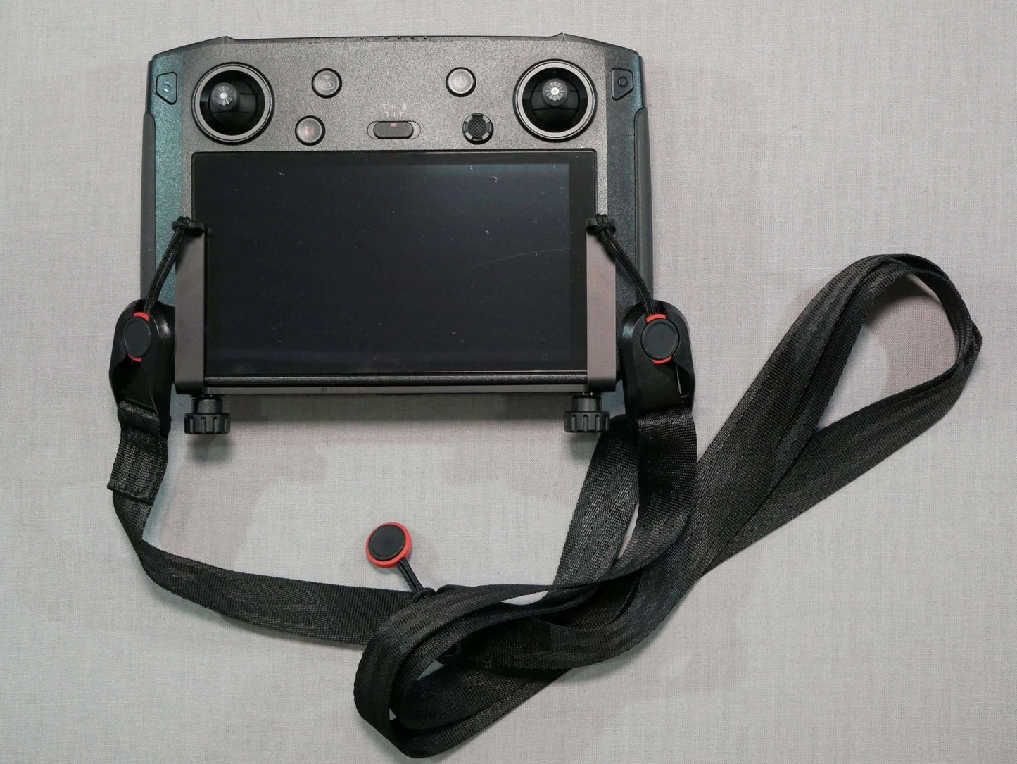 Halter mit Halsgurt schwarz montiert an den DJI RC-Pro Controller. Draufsicht