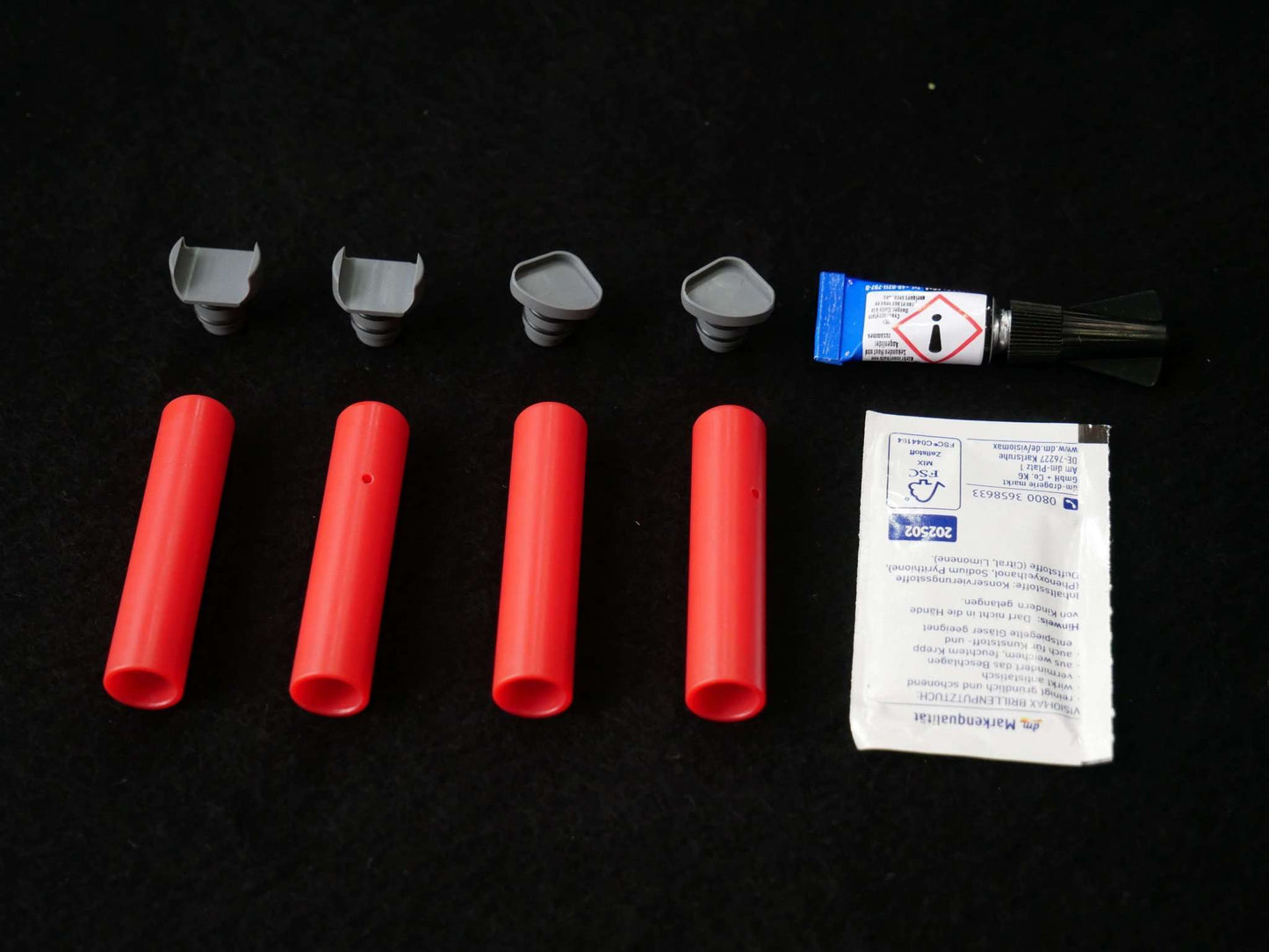 Lieferumfang Landegestell System rot: 4x Adapter, 4x Landefüße, 1x Reinigungstuch, 1 Tube Kleber