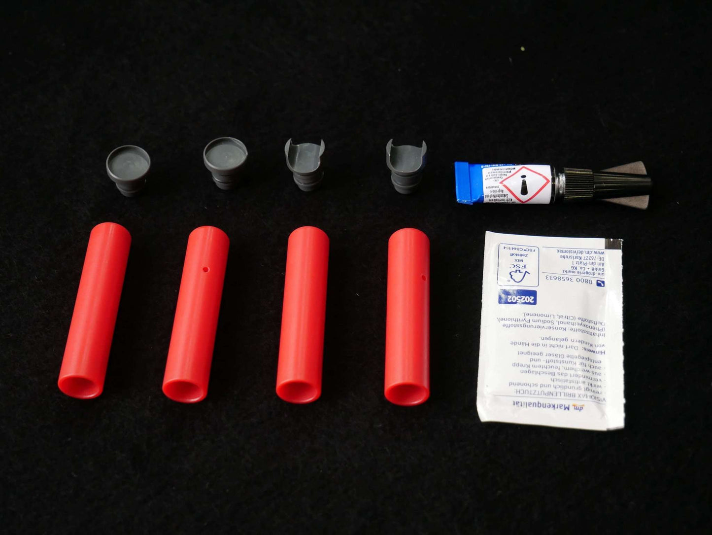 Lieferumfang Landegestell System rot: 4x Adapter, 4x Landefüße, 1x Reinigungstuch, 1 Tube Kleber