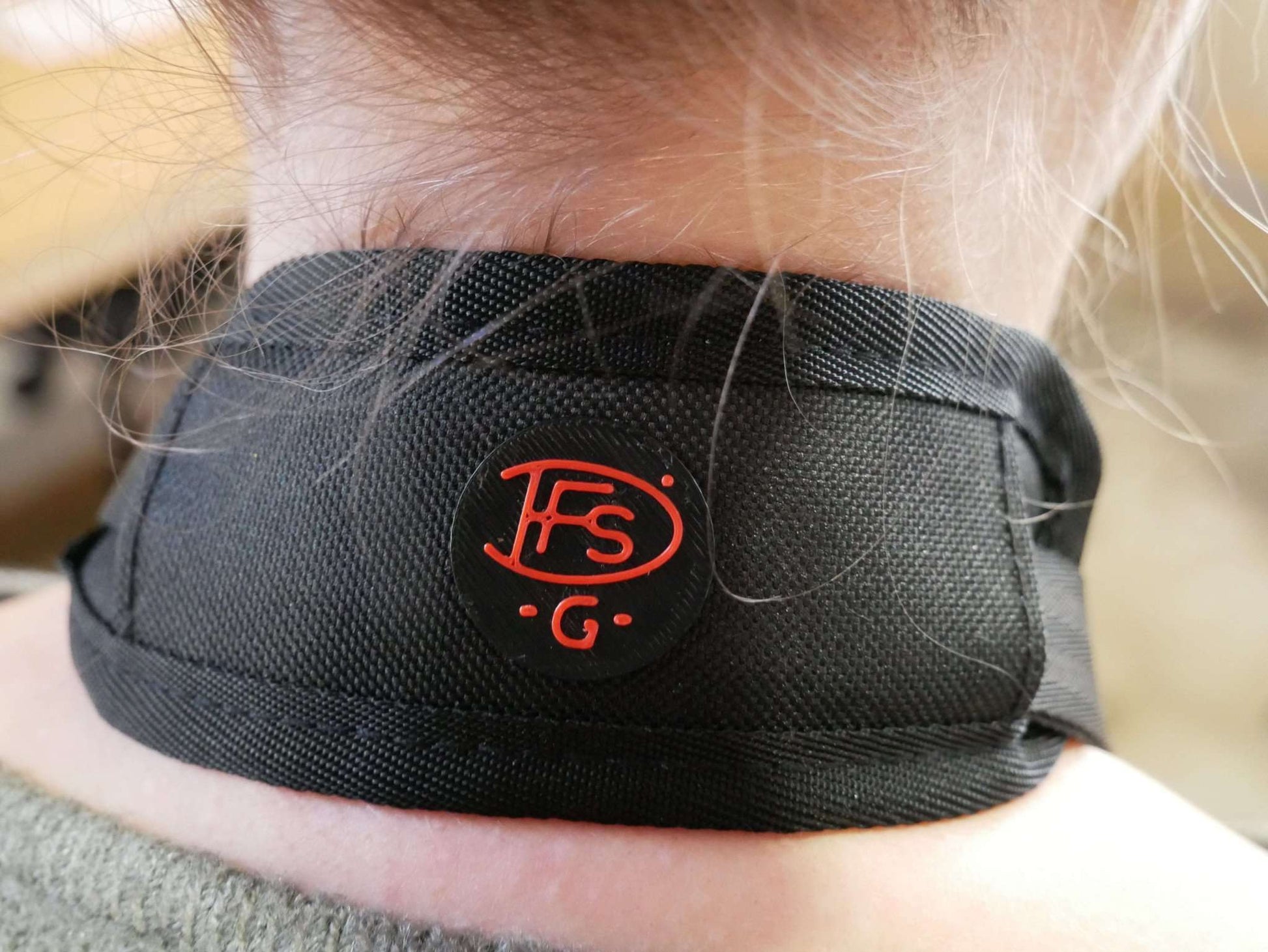 Nähere Ansicht des getragenen Polsters mit DFS-G- Logo angebracht an den Halter mit Halsgurt