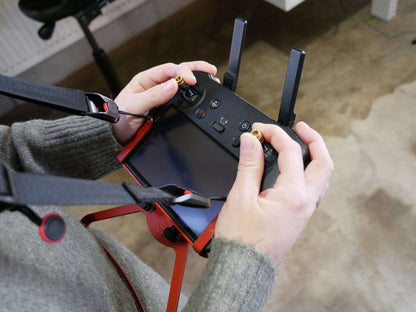 POV-Extender in rot montiert & getragen am DJI RC-Pro Controller mit Halter für Halsgurt